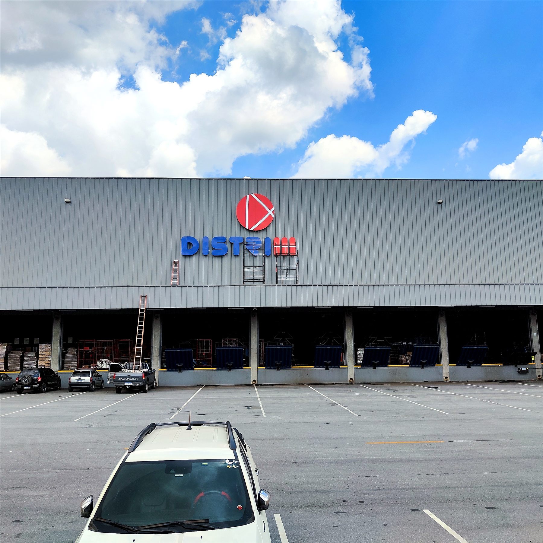 Fachada industrial Distribuid com revestimento metálico e letra caixa