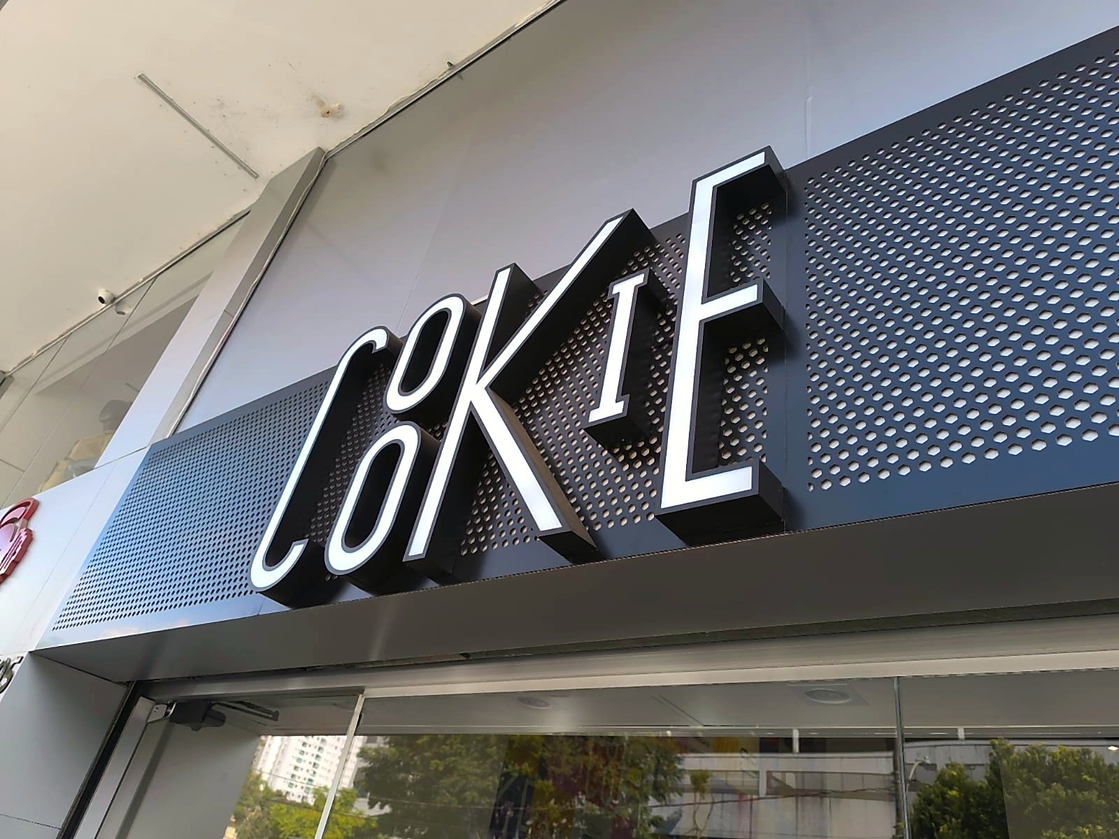 Letra caixa Coke em fachada comercial com acabamento iluminado