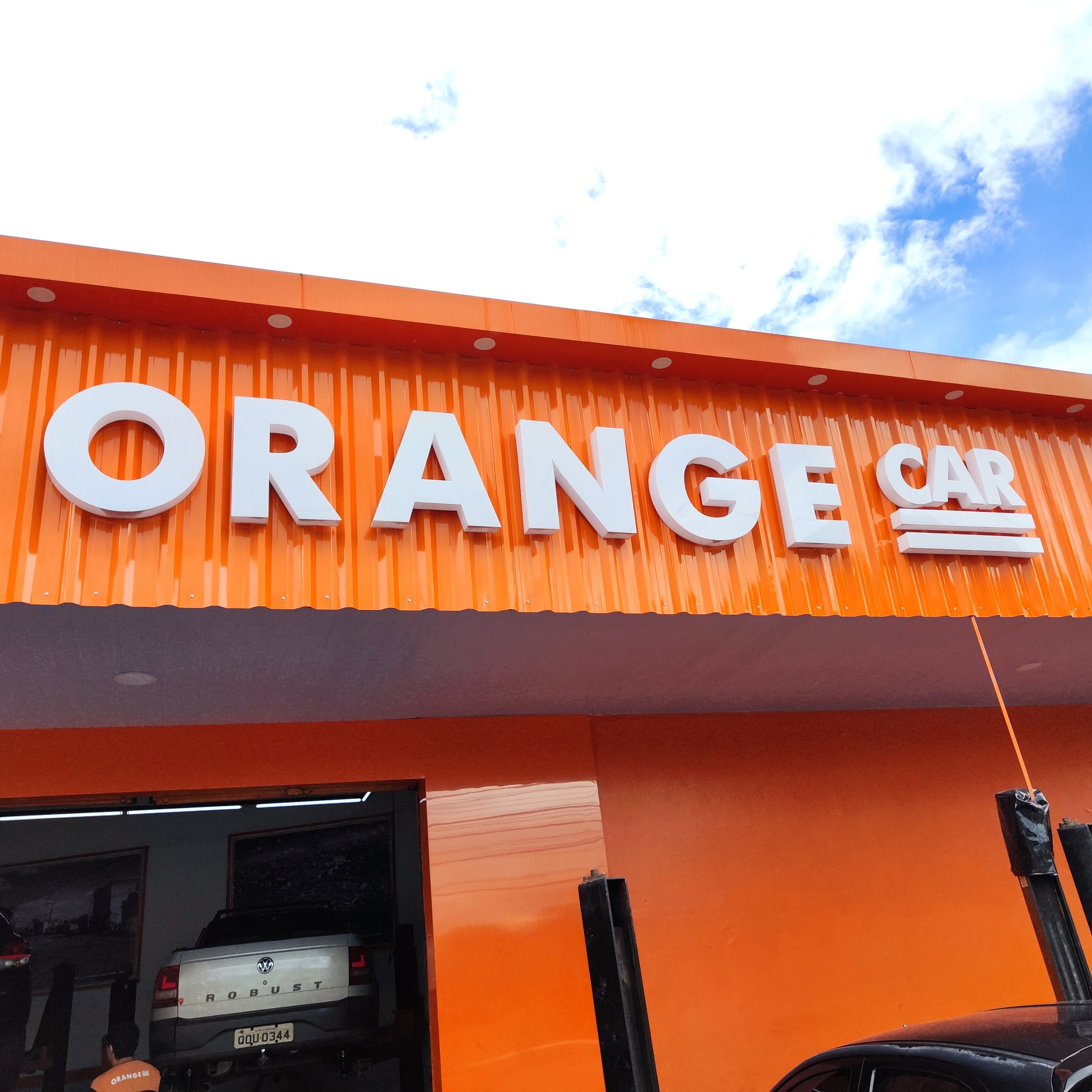 Letra caixa Orange em fachada comercial laranja