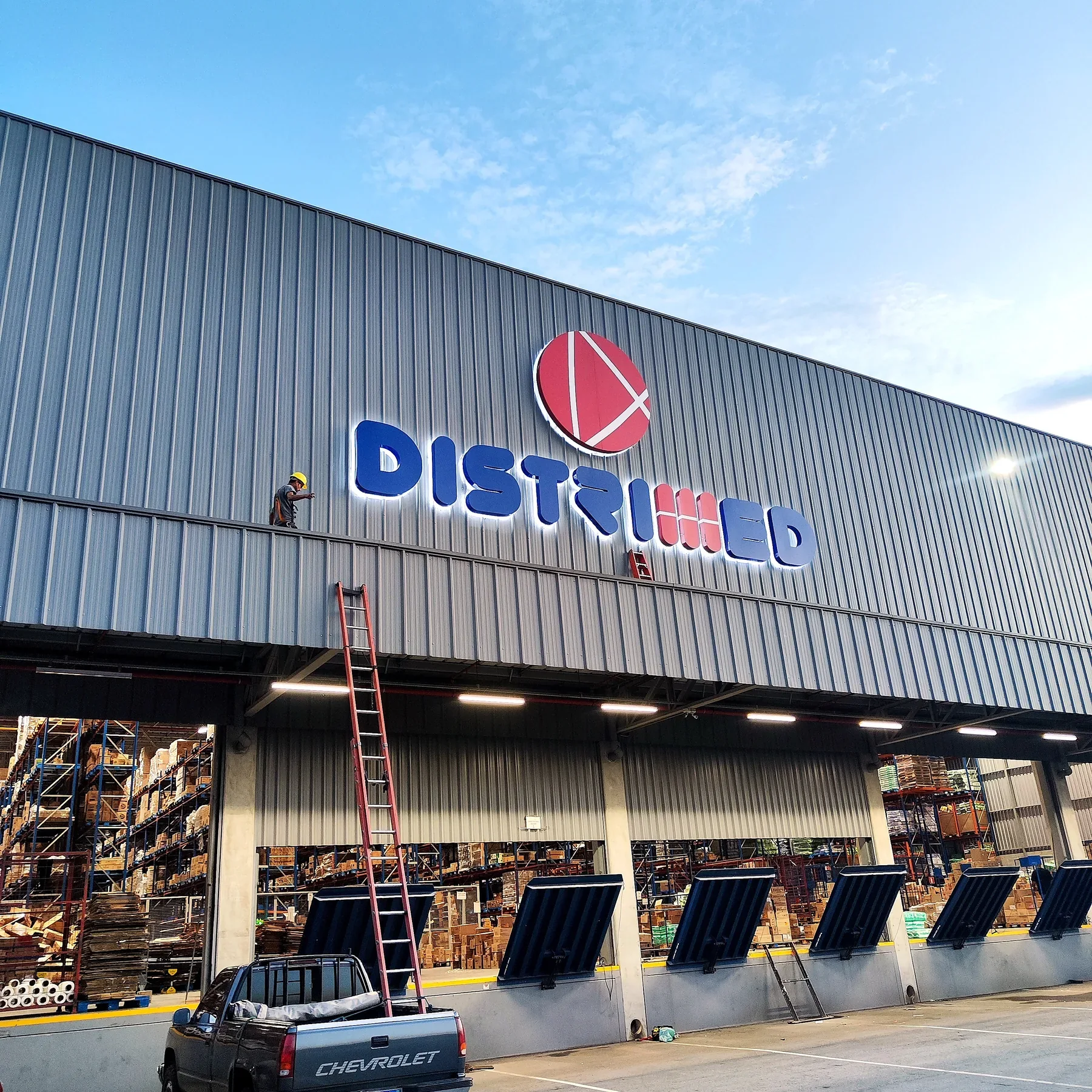 Letreiro luminoso Distribuid em fachada industrial executado pela ARTFICIA