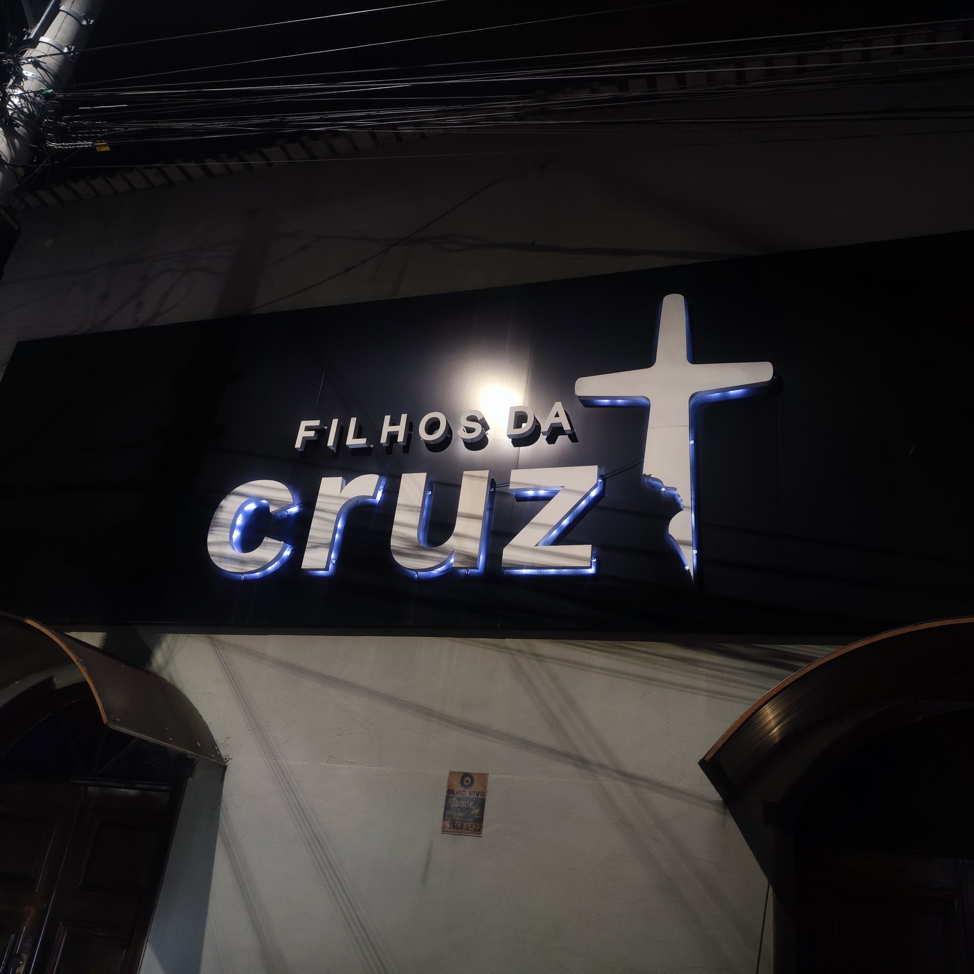 Luminoso Filhos da Cruz em fachada com letreiro iluminado