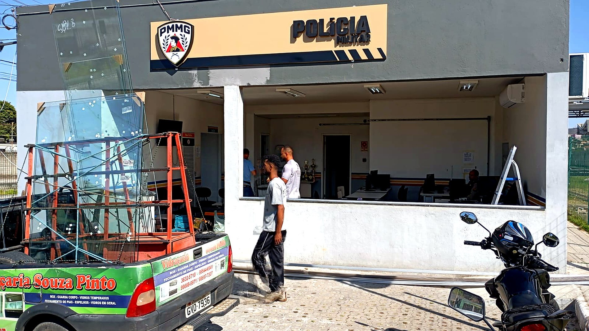 Placa em ACM com letreiro PMMG durante instalacao em fachada
