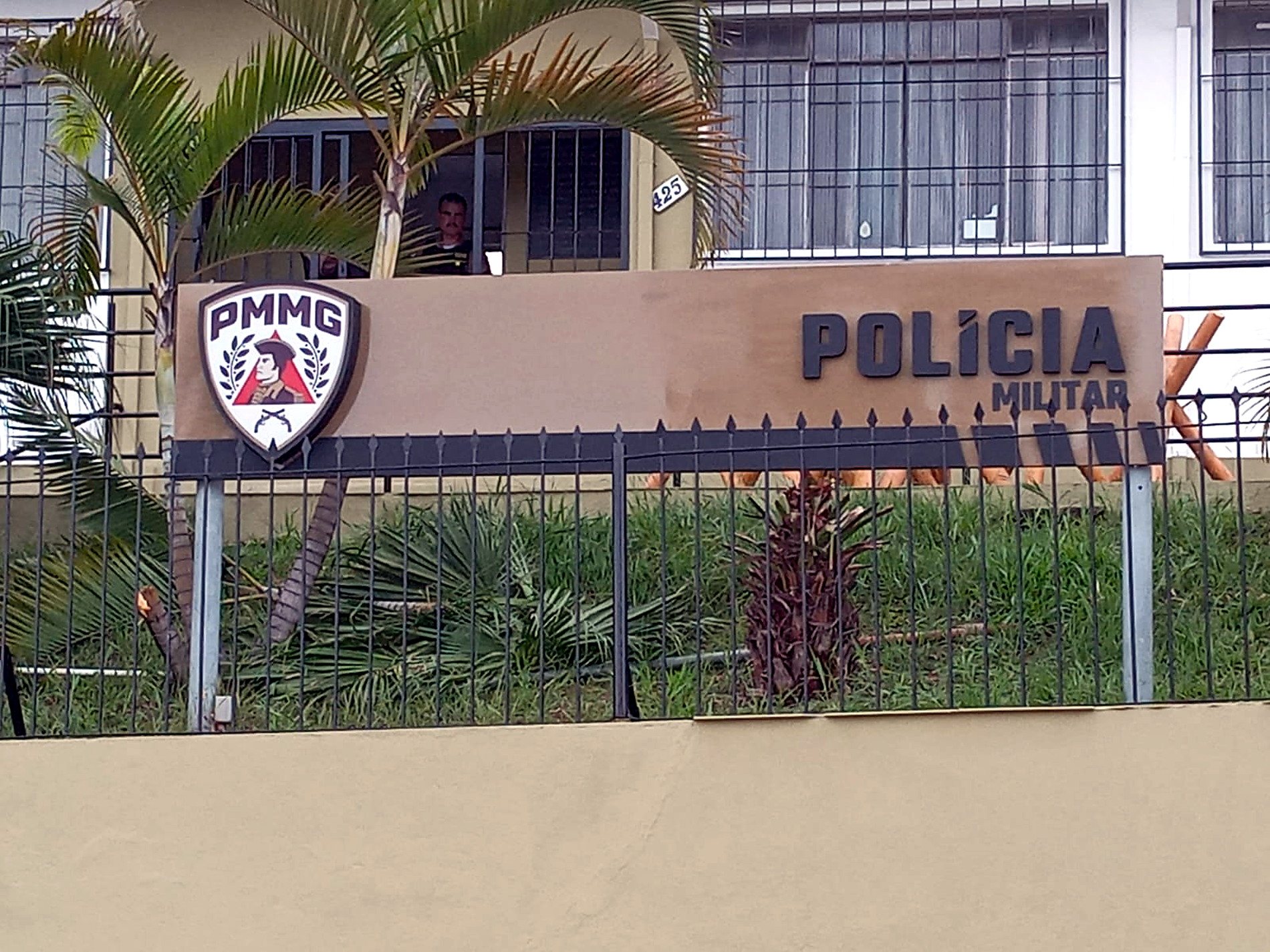 Placa PMMG para comunicacao institucional instalada em fachada
